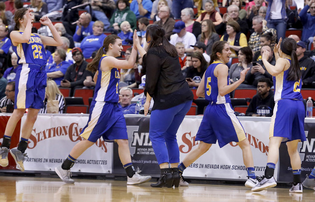 Lowry players slap their coach hand at a timeout during the second half of a Class 3A girls ...
