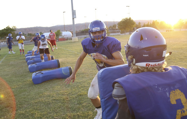 Moapa Valley High School fullback Dalyn Leavitt, second from right, runs through a drill wit ...