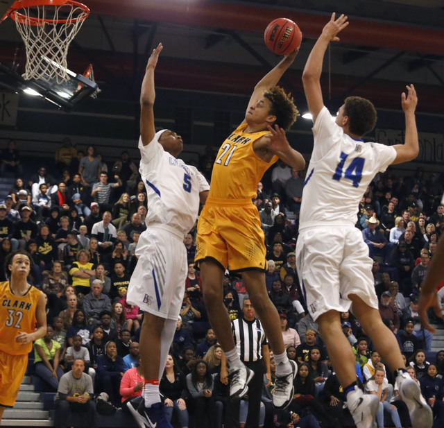 Clark’s Jalen Hill (21) dunks over Bishop Gorman’s Chuck O’Bannon (5) and ...