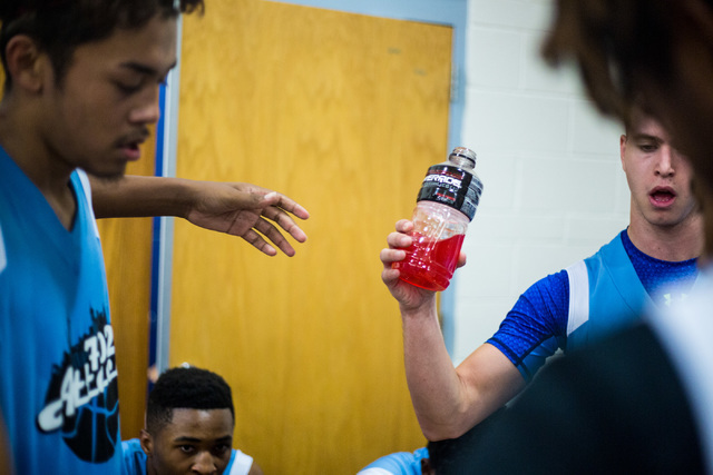 Team members of 702 Attack pass a sports drink during the Fab 48 AAU tournament Thrusday, Ju ...