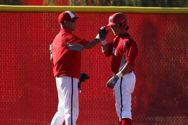 Arbor View’s Nick Quintana is congratulated by coach Jay Guest after hitting a triple ...