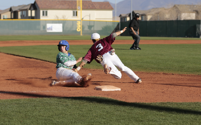 Green Valley sophomore A.J. Amelburu (4) slides into third base and is tagged by Desert Oasi ...