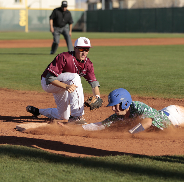 Green Valley sophomore A.J. Amelburu (4) slides back towards third base after being caught b ...