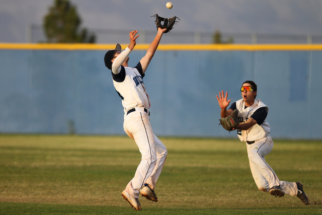 Centennial’s Jake Portaro (24), left, makes a catch in the outfield with his teammate ...