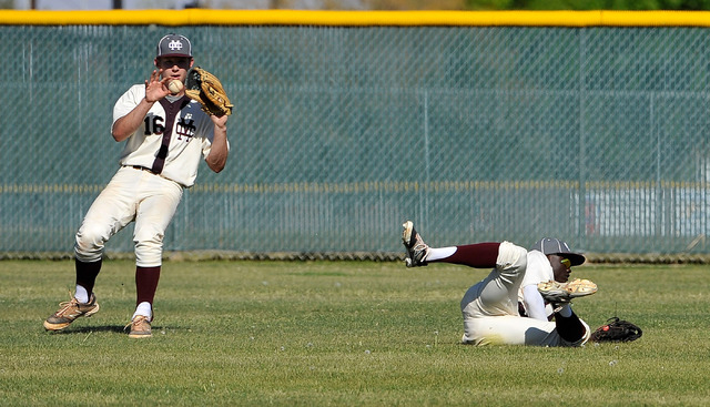 A blooper drops between Cimarron-Memorial outfielders Adam Mitchell, left and Micquel Robins ...