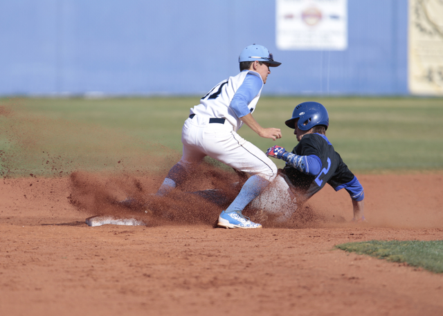 Basic High School senior Cory Wills (2) slides into second base under Centennial High School ...