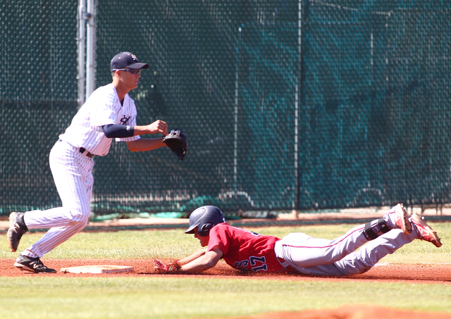 Liberty’s Josh McCollum slides safely into third base as Spring Valley’s Bryce B ...