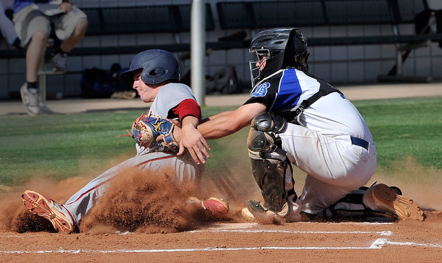 Liberty’s Dan Skelly is tagged out at home plate by Basic catcher Brandon Smith to end ...