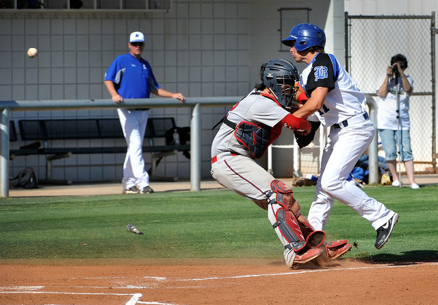 Basic’s Logan Green, right, scores in the first inning Monday as the ball gets by Lib ...