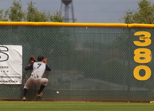 Spring Valley’s Connery Callaway (7) runs into the fence trying to catch a fly ball of ...