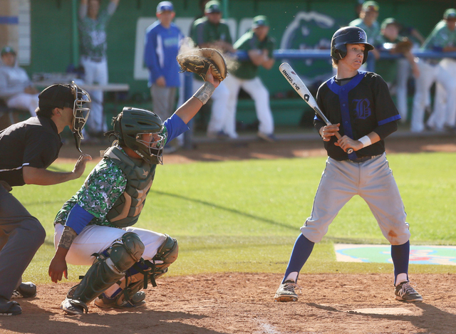 Green Valley’s Ty Burger, center, catches a high pitch as Basic’s David Hudleson ...