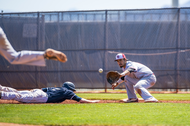 Shadow Ridge infielder Nick Erickson slides back to first base as Desert Oasis first baseman ...