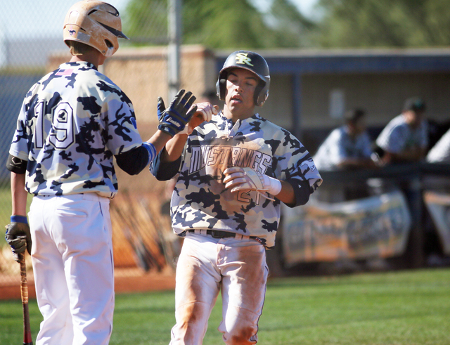 Shadow Ridge’s Eric Jordan, right, crosses home plate by Trevin Reynolds to score the ...