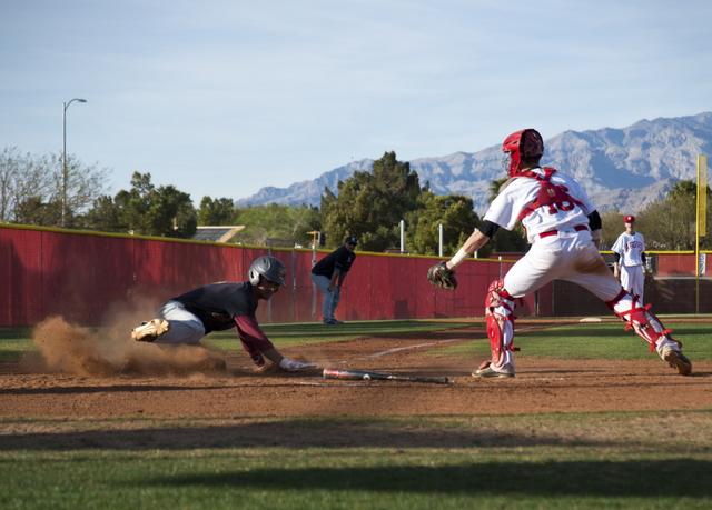 Faith Lutheran’s Josh Harmonay (9) slides into home plate as Arbor View’s Joe Fi ...