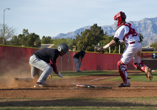 Faith Lutheran’s Josh Harmonay (9) slides into home plate as Arbor View’s Joe Fi ...