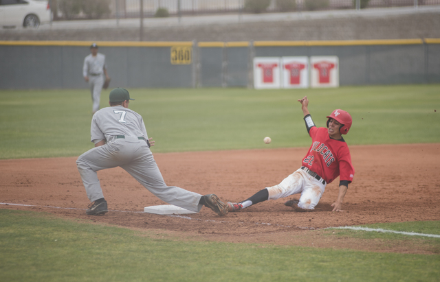 Las Vegas High School’s Jaime Solis (22) slides into third base as Las Vegas High Scho ...