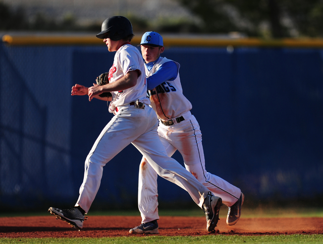 Centennial third baseman Garrett Holden tags out Liberty base runner Jacob Klein in the seco ...