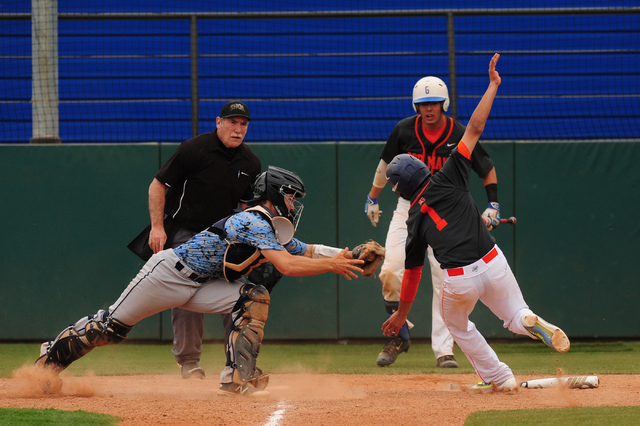 Centennial catcher Hayden Grant tags out Bishop Gorman base runner Jorel Hingada at home pla ...