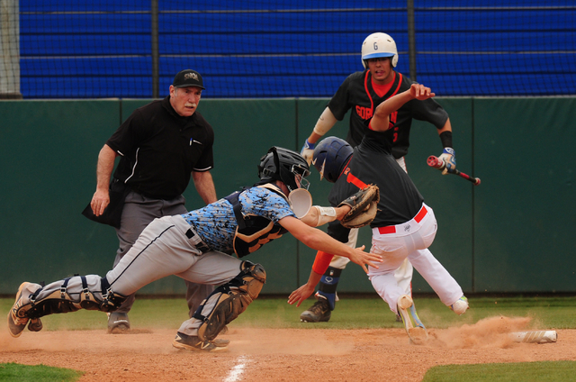 Centennial catcher Hayden Grant tags out Bishop Gorman base runner Jorel Hingada at home pla ...
