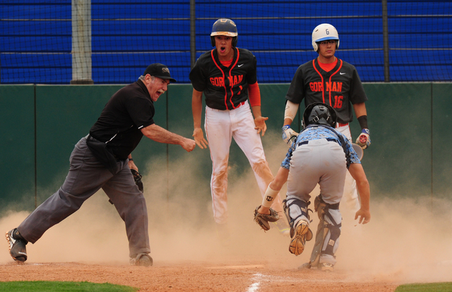 Bishop Gorman base runner Jorel Hingada reacts after being called out at home plate by umpir ...