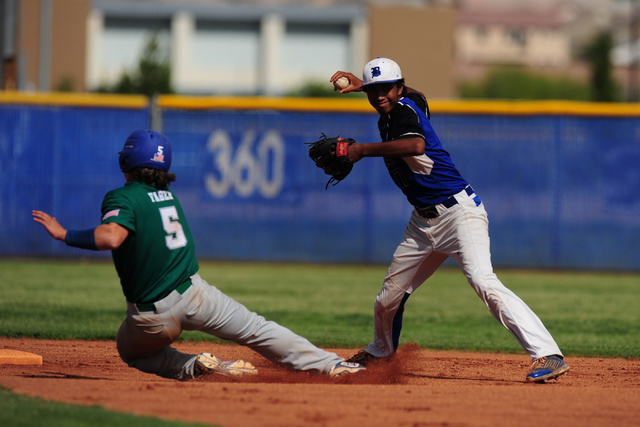 Basic shortstop Garrett Giles turns a double play while Green Valley base runner Eric Faber ...