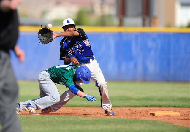 Green Valley base runner Brandon Bayne dives back to second base after looking to stretch a ...