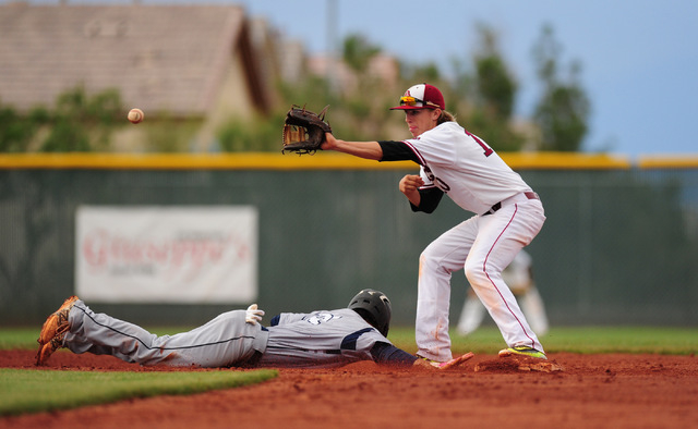 Shadow Ridge baserunner Eric Jordan dives back to second base after Desert Oasis shortstop B ...