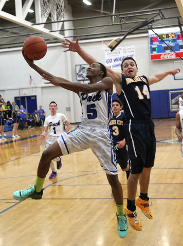 Basic guard Kerry Keyes (5) goes up for a shot in front of Boulder City guard/forward Trento ...