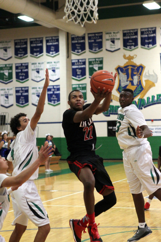 Las Vegas shooting guard Patrick Savoy (22) shoots between Green Valley shooting guard Xavie ...