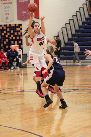 Liberty’s Nancy Caballero (41) leaps up and out while passing the ball over the head o ...