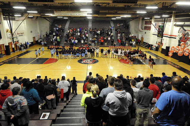 Players and fans from both Las Vegas High and Canyon Springs observe a moment of silence in ...
