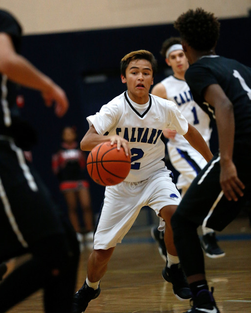Calvary Chapel’s Dylan Sims (2) tries to drive past Mountain View’s players duri ...