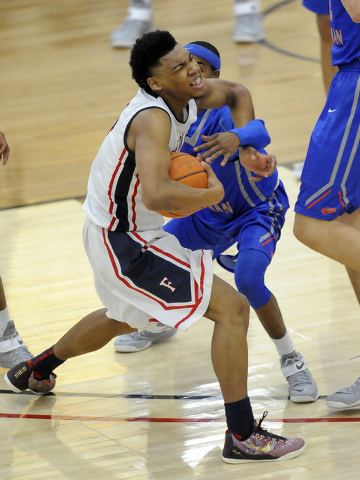 Bishop Gorman guard Julian Payton, right, attempts to strip the ball away from Findlay Prep ...