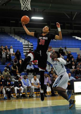 Las Vegas’ Tyler Bey (30) goes past Canyon Springs’ Antonio Longmyers on Monday. ...