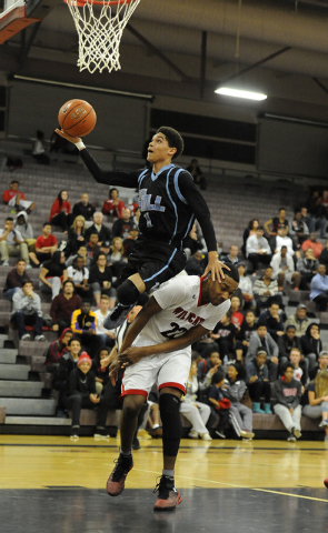 Foothill guard Kevin Woodland (1) drives by Las Vegas guard Patrick Savoy (22) for a layup o ...