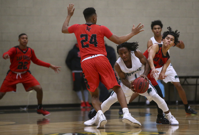 Rancho guard Jahleel Stevens (1) looks to get past Las Vegas guards Zach Matlock (24) and Jo ...