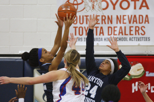 Canyon Springs guards Mia Moss, left, and Daijhan Cooks grab a rebound from Reno center Mall ...