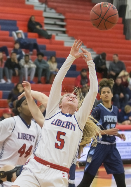 Liberty’s London Pavlica (5) reaches for a rebound during the Patriots home matchup wi ...