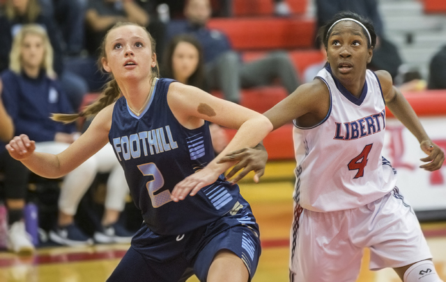 Liberty’s Star Walker (4) fights for a rebound with Foothills Aqui Williams (2) during ...