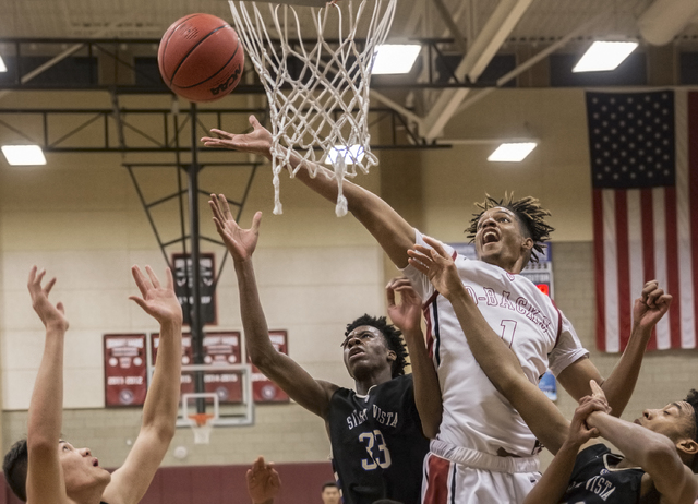 Desert Oasis’ Tyler McClendon (1) leaps for a rebound over Sierra Vista’s Jalen ...