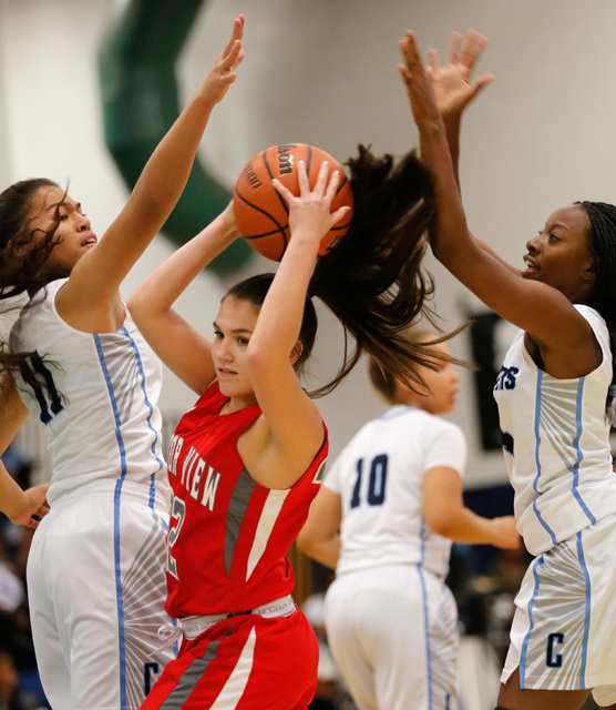Arbor View’s Caylin Trillo, center, keeps a ball away from Canyon Springs’ Jeane ...
