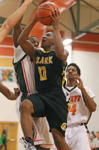 Clark’s Colby Jackson, center, goes up for a lay-up around Mojave’s Melvin Irvey, le ...