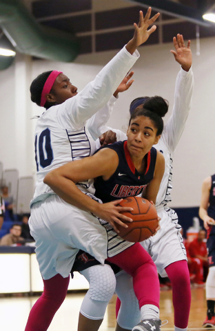 Liberty’s Paris Strawther, center, gets tangled up with Canyon Springs defense Dre&#82 ...