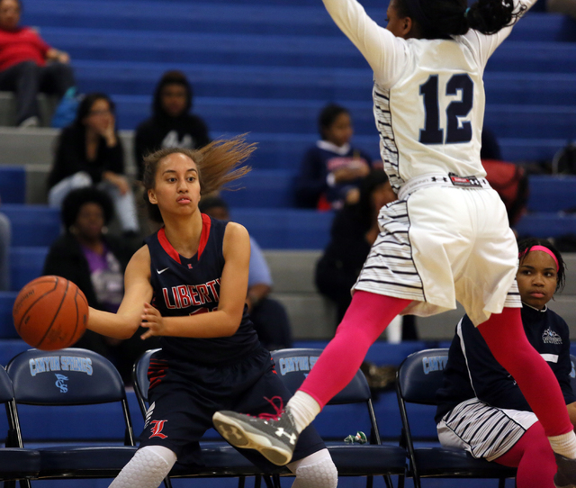 Liberty’s Kaily Kaimikaua, left, looks to pass around Canyon Springs’ LaKiya Yar ...