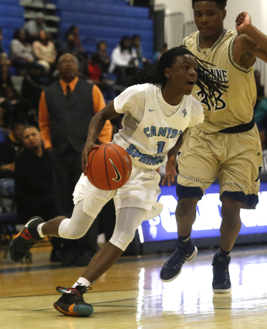 Canyon Spring’s DeVante Williams (1) drives towards the hoop pass Cheyenne’s Fra ...