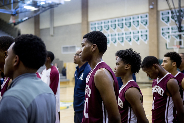 Agassi Prep Forward Miles Mixon (40), center, pays respect to the American flag before the g ...