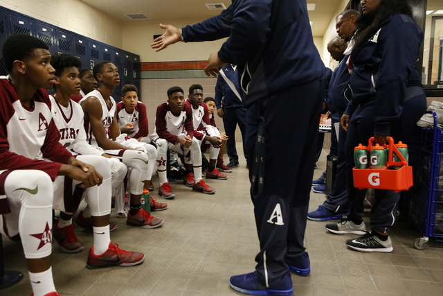 Agassi players listen to their coach during halftime at a boys basketball game on Wednesday, ...