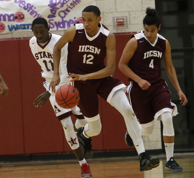Innovations International’s Justin Evans (12) drives down the court during a boys bask ...