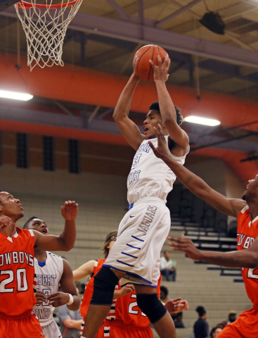 Desert Pines’ Trevon Abdullah, center, goes up for a rebound during a game against Chaparr ...