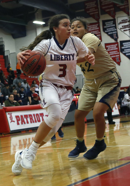 Liberty’s Celine Quintino (3) drives towards the hoop pass Spring Valley’s Myra ...